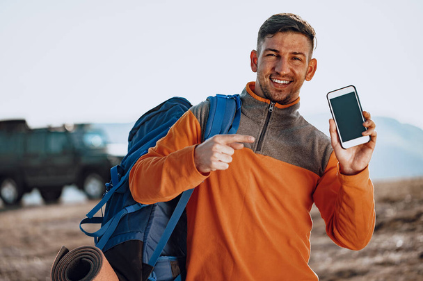 Young caucasian man traveller using his smartphone - Foto, Imagen