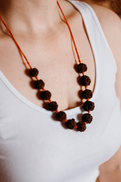 Collier de perles Rudraksha sur la poitrine de la femme caucasienne, gros plan  - Photo, image