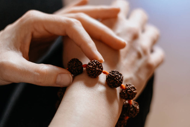 Armband aus Rudraksha-Perlen an der Hand einer kaukasischen Frau, Nahaufnahme - Foto, Bild