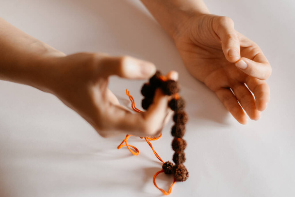 Rudraksha beads necklace in female prayer's hand, close up - Photo, Image