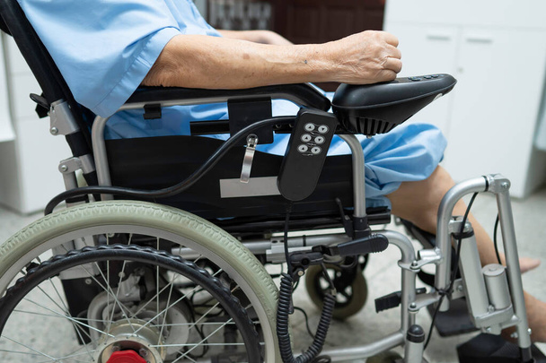 Asyalı yaşlı ya da yaşlı kadın hasta elektrikli sandalyede, hemşire koğuşunda uzaktan kumandalı, sağlıklı güçlü tıbbi konsept.  - Fotoğraf, Görsel