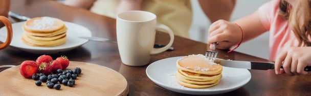 cropped view of girl having breakfast while eating delicious pancakes, horizontal image - Photo, Image