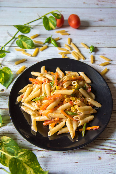 Pasta with vegetables and condiments on a background with use of selective focus. - Photo, Image