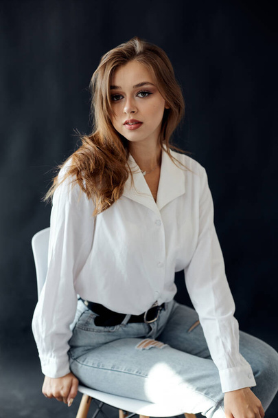 Girl in a white shirt on a dark background - Photo, Image