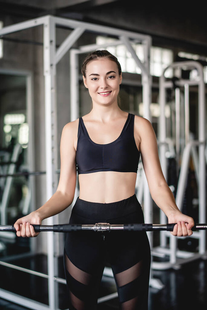 Cinematic tone of young attractive fitness woman exercise with machine in gym. Individual sport to fit muscles of body for healthy life concept.  - Photo, image