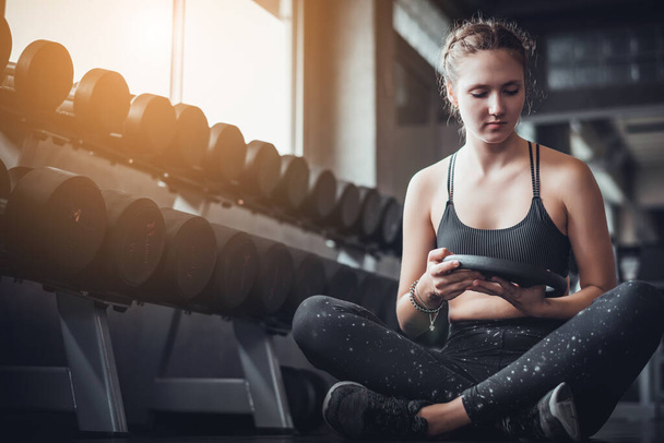 Cinematic tone of young attractive fitness woman exercise with machine and dumbbell in gym. Individual sport to fit muscles of body for healthy life concept. - Foto, Imagen