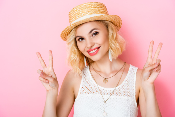young woman in straw hat showing peace sign on pink  - Photo, Image