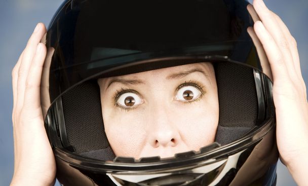 Woman with a motrcycle helmet and surprised expression - Foto, imagen