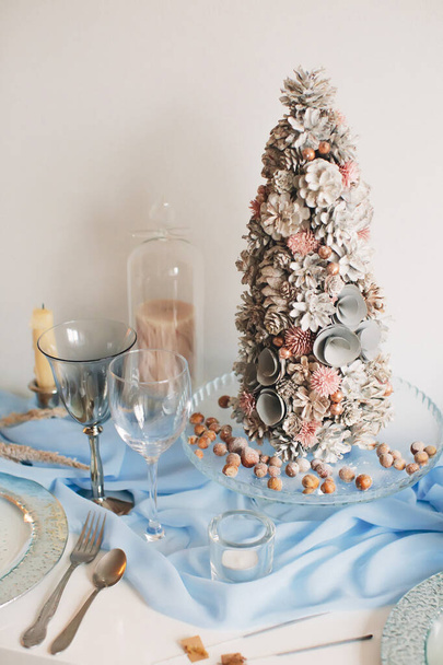 Festive table setting for Christmas and New Year in blue and pink colors, with an artificial Christmas tree. Soft focus. - Photo, Image