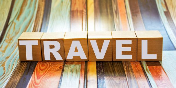 TRAVEL word concept written on wooden cubes blocks lying on a light table and light background - Photo, Image