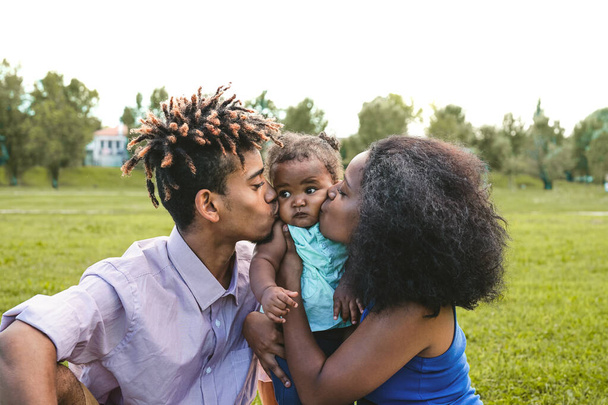 Glückliche afrikanische Familie beim gemeinsamen Spaß im öffentlichen Park - Schwarzer Vater und Mutter genießen Wochenende mit ihrer Tochter - Menschen lieben und Eltern-Einheit-Konzept - Foto, Bild