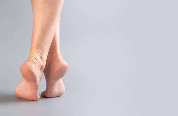 female bare feet on light grey background - Φωτογραφία, εικόνα