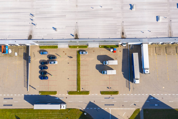 Вид с воздуха на склады или промышленный завод или логистический центр сверху. Вид с воздуха на промышленные здания и оборудование на закате - Фото, изображение