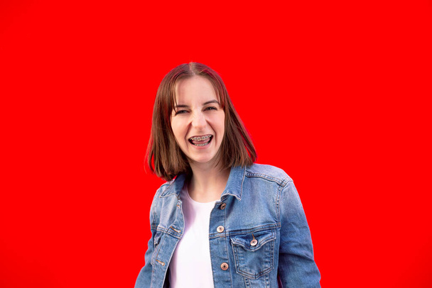 menina feliz com aparelho contra fundo vermelho
 - Foto, Imagem