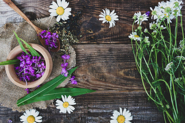 kwiaty i liście ivan rumianku herbaty na drewnianym rustykalnym stole, Epilobium angustifolium. Wodorosty (Rosebay Willowherb), różowe kwiaty w drewnianej łyżce, lecznicze zioła, przestrzeń do kopiowania - Zdjęcie, obraz