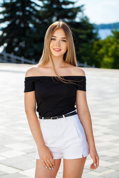 Close up portrait of a young beautiful blonde woman in white shorts - Фото, зображення