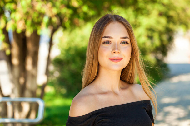 Close up portrait of a young beautiful brunette woman in summer park - Фото, изображение