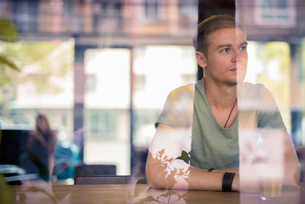 Portret przystojnego mężczyzny relaksującego się w kawiarni - Zdjęcie, obraz