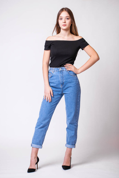 Beautiful sexy brunette woman in blue jeans. Fashion model in jeans clothing. Isolated on gray studio background - Φωτογραφία, εικόνα