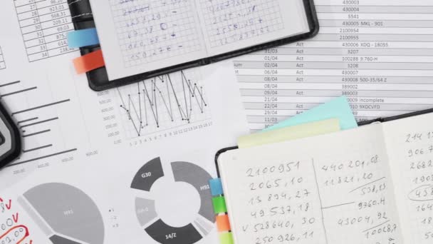 oficina de negocios escritorio primer plano - spreadshets financieros e informes con datos para el análisis y la contabilidad, conjunto de documentos, diversos elementos para la contabilidad - Metraje, vídeo