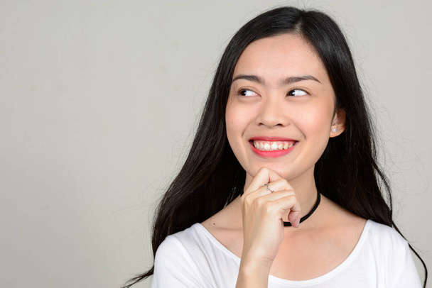 Студія постріл молодий красиві азіатські жінки на сірому тлі - Фото, зображення