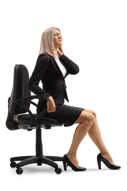 Profesyonel bir kadın masa başında oturuyor ve beyaz arka planda izole edilmiş ağrılı bir boynu tutuyor. - Fotoğraf, Görsel