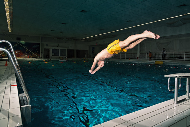 gezonde actieve senior man met baard in zwembad binnen div - Foto, afbeelding