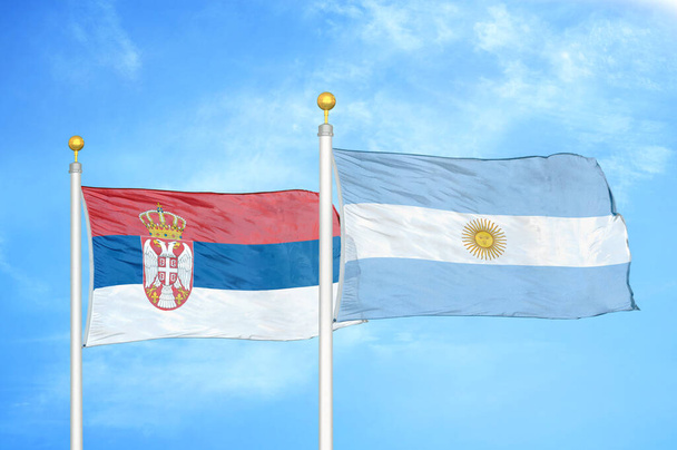 Serbie et Argentine deux drapeaux sur mâts et ciel bleu nuageux - Photo, image