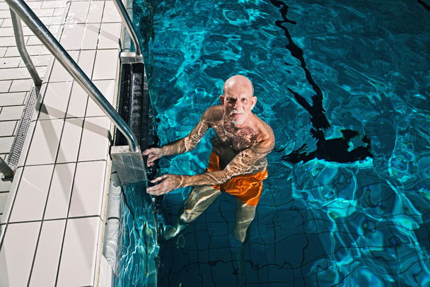 υγιή ενεργό ανώτερος άνθρωπος με γενειάδα στην εσωτερική πισίνα. Εμείς - Φωτογραφία, εικόνα