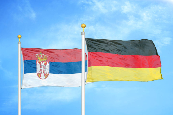 Sırbistan ve Almanya bayrak direkleri ve mavi bulutlu arka planda iki bayrak - Fotoğraf, Görsel