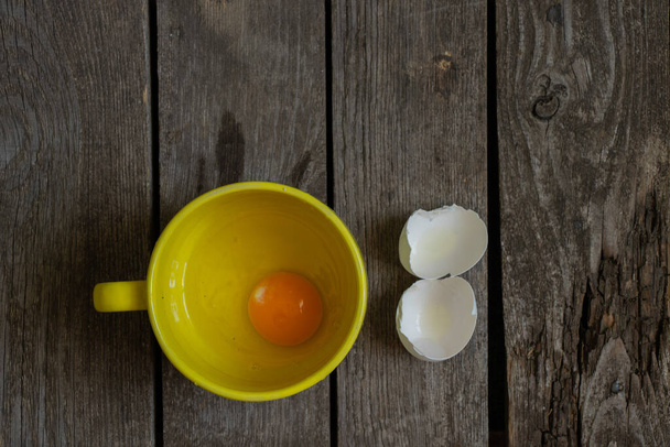 rikki kana muna keltainen kuppi puinen pöytä ja vieressä scarloop - Valokuva, kuva