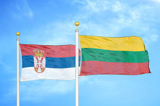 Serbien und Litauen zwei Flaggen auf Fahnenmasten und blauer bewölkter Himmel Hintergrund - Foto, Bild