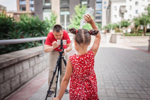 Make money online. Middle aged father recording film with his daughter for family channel, video blogger, internet earning and freelance remote work - Photo, Image