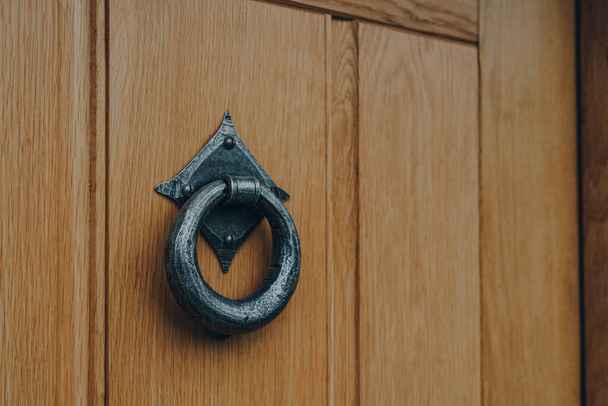 Закрыть металлический дверной молоток на деревянной входной двери дома. - Фото, изображение