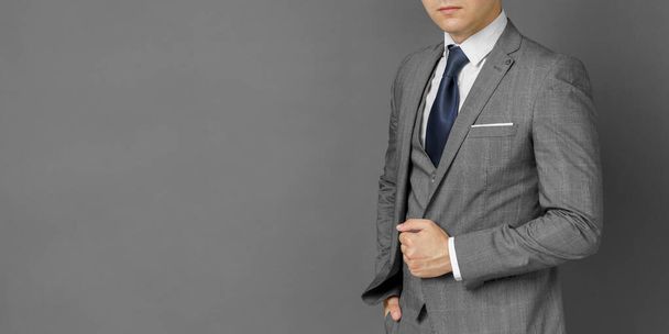 Portrait of a businessman in a suit. No face visible. Gray background. Business and finance concept - Photo, Image