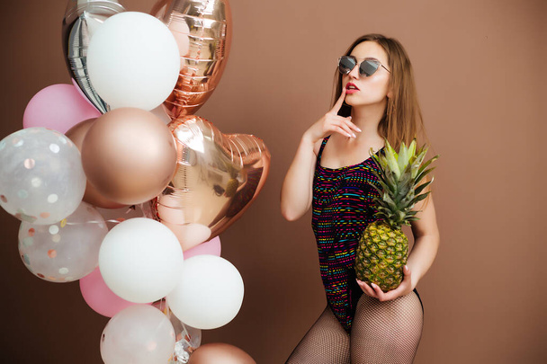 erotic swimsuit girl with pineapple fruit holding balloons - 写真・画像