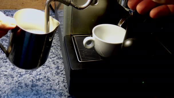 Barista lämmittää maitoa kuumalla höyryllä espressokahvinkeittimestä. - Materiaali, video