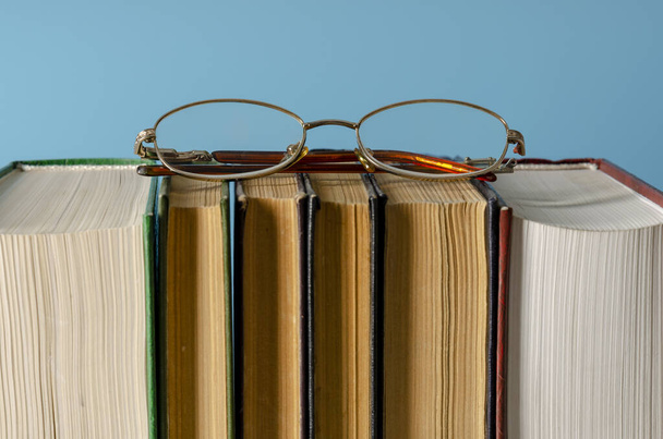 Bücher mit Brille auf farbigem Hintergrund. Internationaler Alphabetisierungstag - Foto, Bild