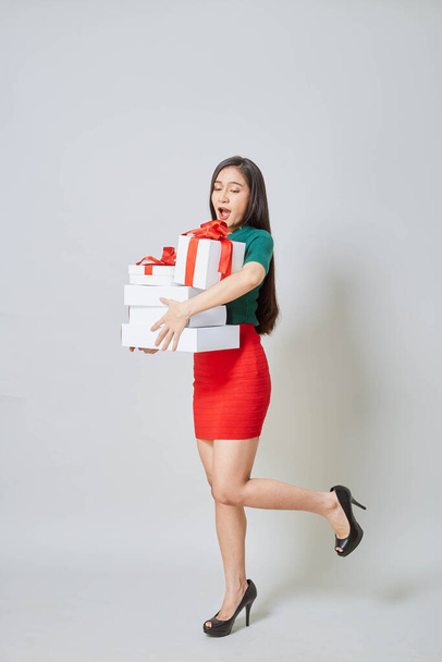 Beautiful asian girl with christmas presents against white background. - Foto, afbeelding