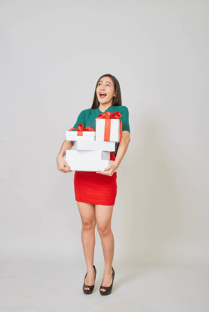 Beautiful asian girl with christmas presents against white background. - Zdjęcie, obraz