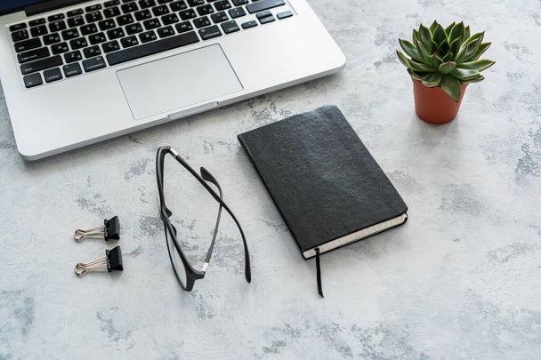 laptop, black diary and glasses on table on white background - Φωτογραφία, εικόνα