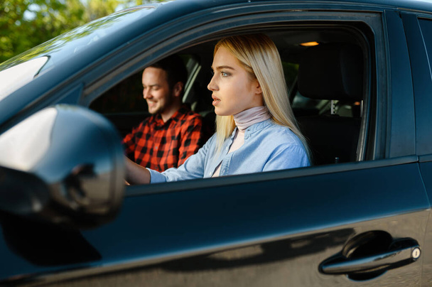 Kobieta uczeń i męski instruktor w samochodzie, szkoła jazdy. Mężczyzna uczy kobietę prowadzić samochód. Kształcenie kierowców - Zdjęcie, obraz