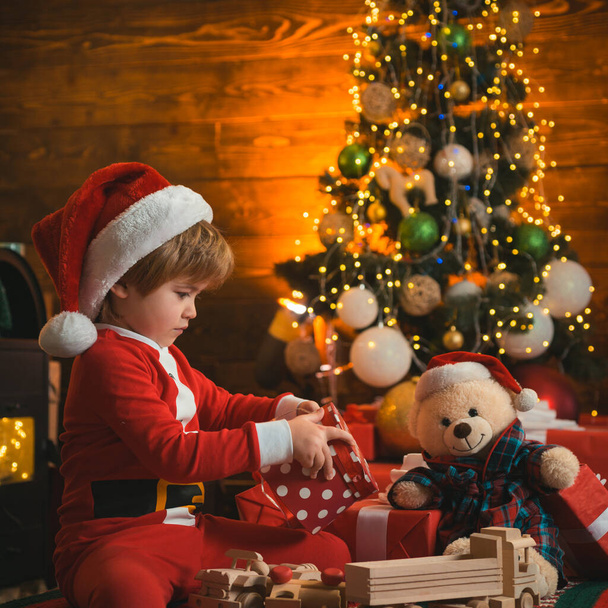 Happy new year. Christmas interior. Kid having fun near Christmas tree indoors. Winter delivery service for kids. - Photo, Image