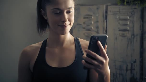 woman using smart phone with personal trainer workout app at home. Woman preparing for workout using fitness app. Close orbit shot.Woman using mobile phone while resting during fitness training  - Záběry, video
