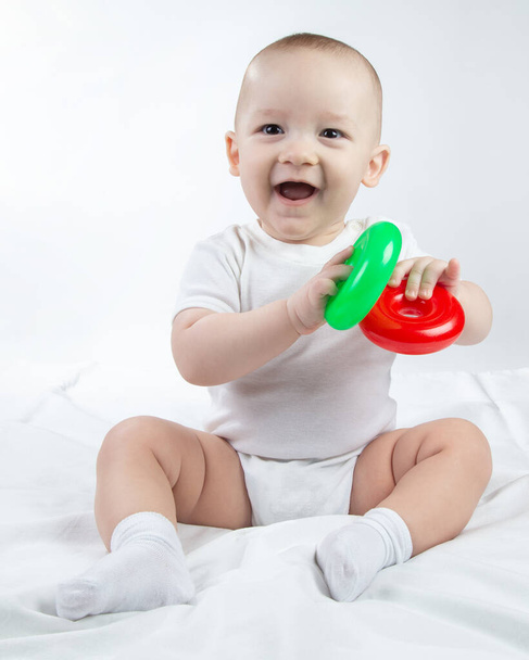 Foto eines lächelnden neun Monate alten Babys mit hellem Spielzeug - Foto, Bild