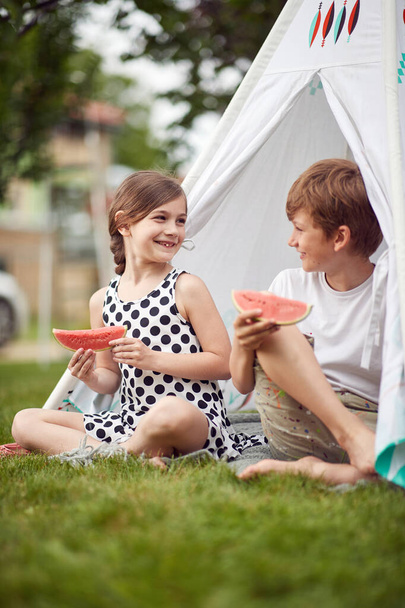 Children eating watermelon in a camp on a beautiful day - Φωτογραφία, εικόνα