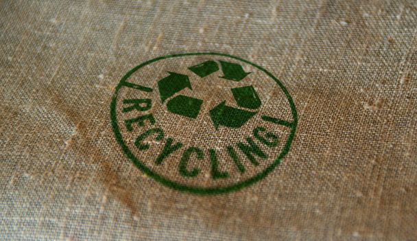 Sello de reciclaje impreso en saco de lino. Símbolo de reciclaje, flechas, materiales reciclables, protección del medio ambiente y concepto seguro para la tierra. - Foto, Imagen