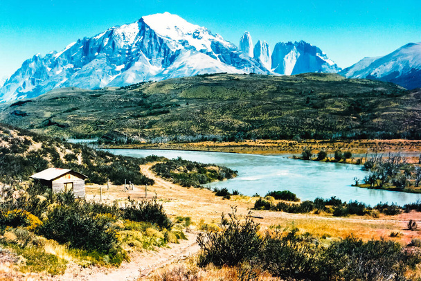 Şili 'deki Ulusal Park Torres del Paine' de muhteşem bir manzara. Küçük ev, güzel dağlar ve nehir. - Fotoğraf, Görsel