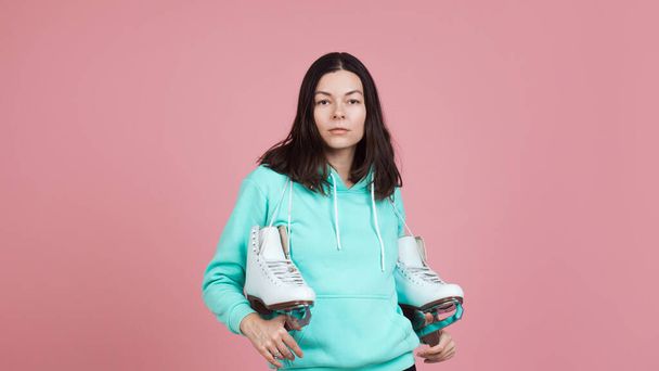 Figure skating for adults, Hobbies and a healthy lifestyle. A young woman in a bright sweatshirt with figure skates - Φωτογραφία, εικόνα