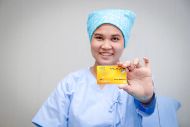Der Patient hält eine Kreditkarte, um die Krankheit zu behandeln. Holen Sie sich gesundheitliche Vorteile und mehr. Kreditkarten-Attrappe. Krankenhausdienstkonzepte - Foto, Bild